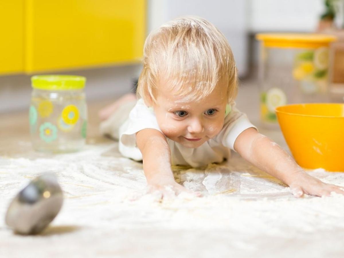 Chłopiec bawi się na podłodze w kuchni