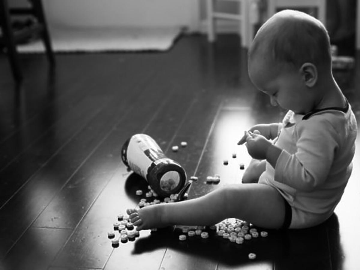 Dziecko siedzi na podłodze i bawi się płatkami śniadaniowymi