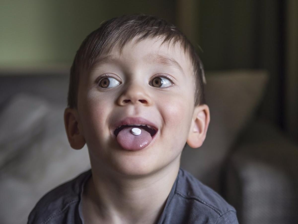 Dziecko z tabletką jodową na języku