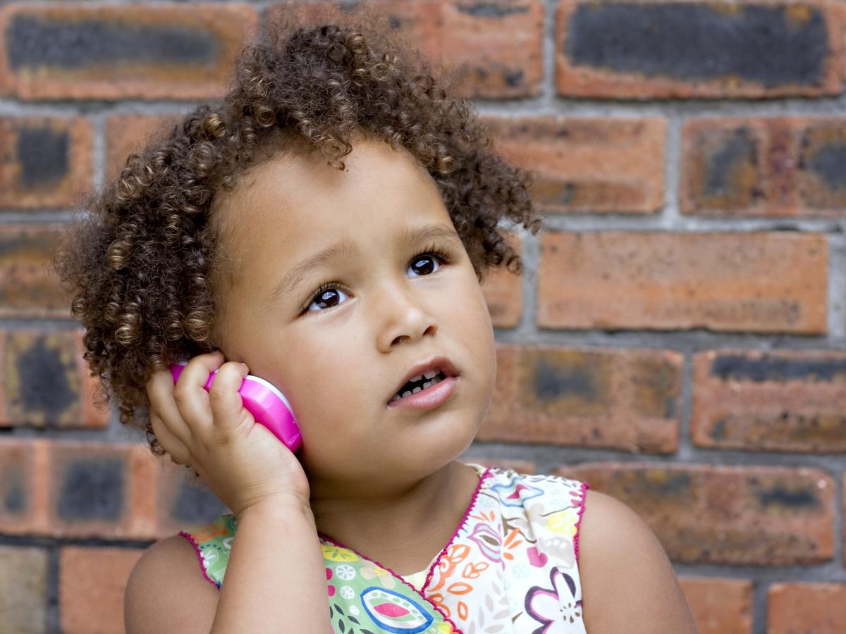 Dziewczynka rozmawia przez zabawkowy telefon