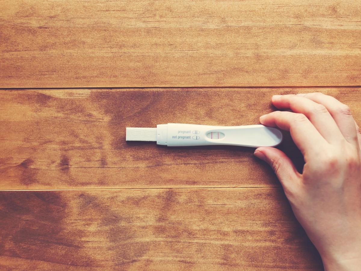 Kobieta trzyma test ciążowy
