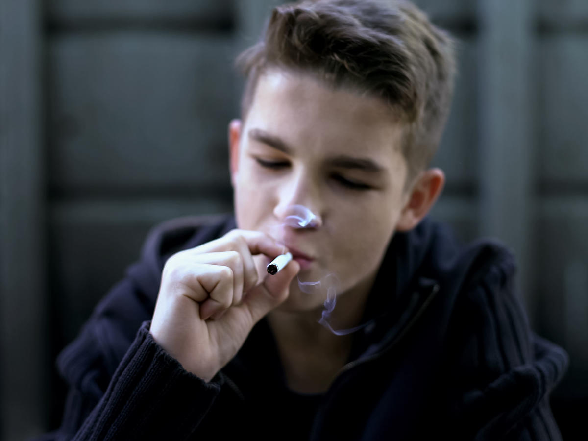 Chłopiec, który pali papierosy