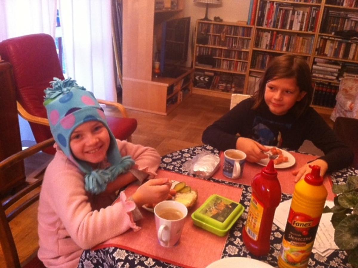 Dzieci w czapkach jedzą śniadanie