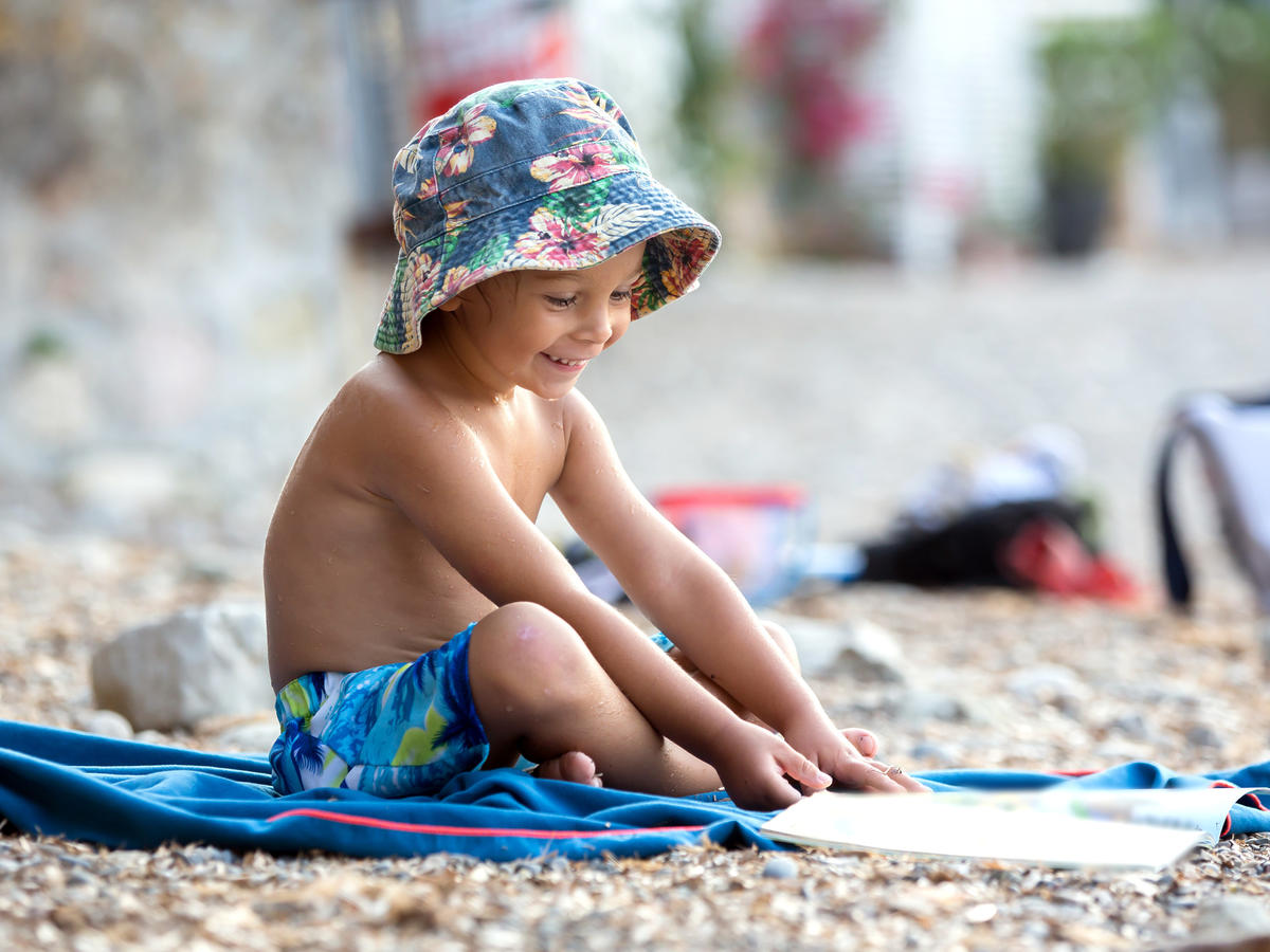 Dziecko z książką na plaży