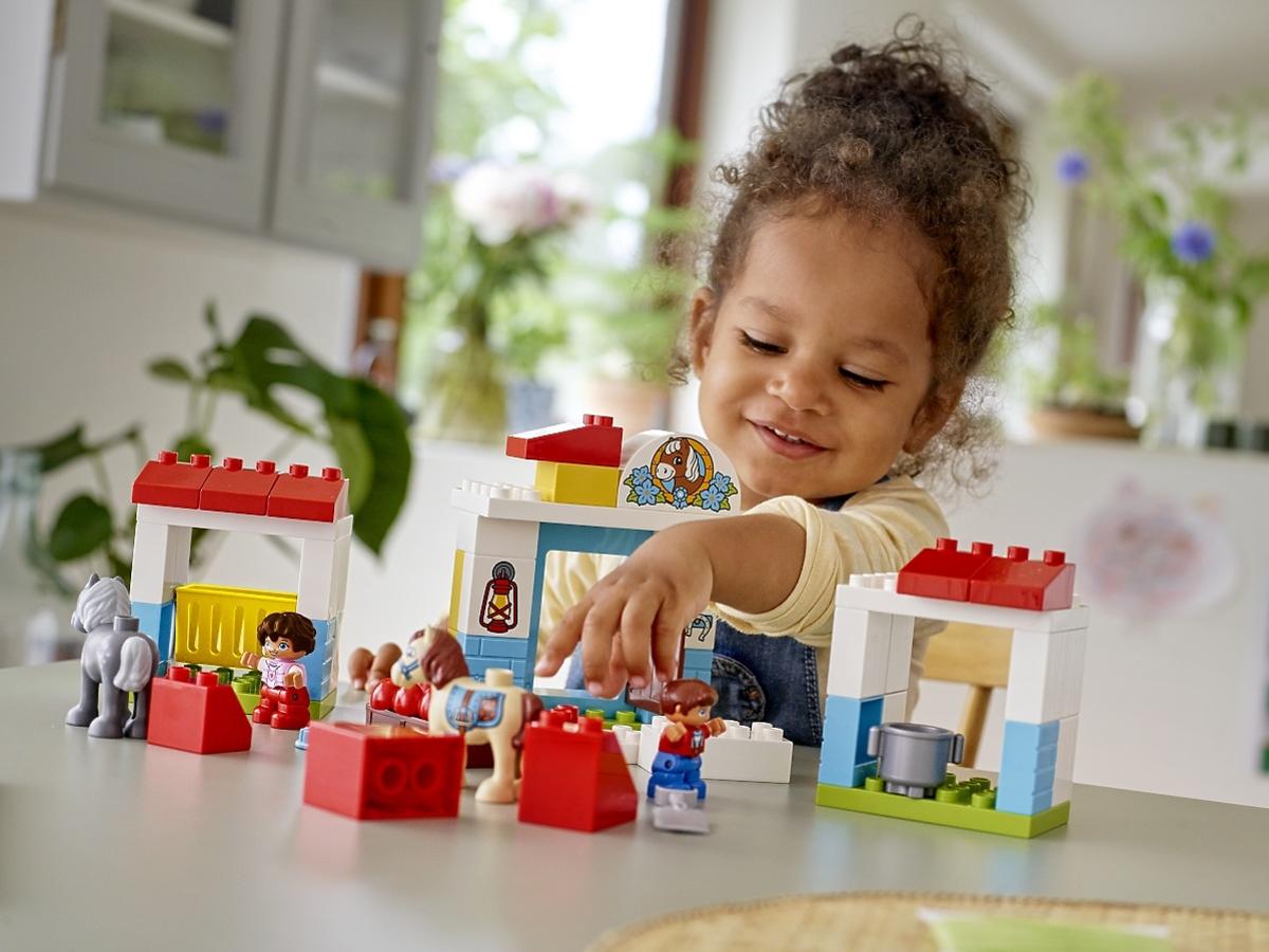 dziewczynka bawi się klockami Lego Duplo