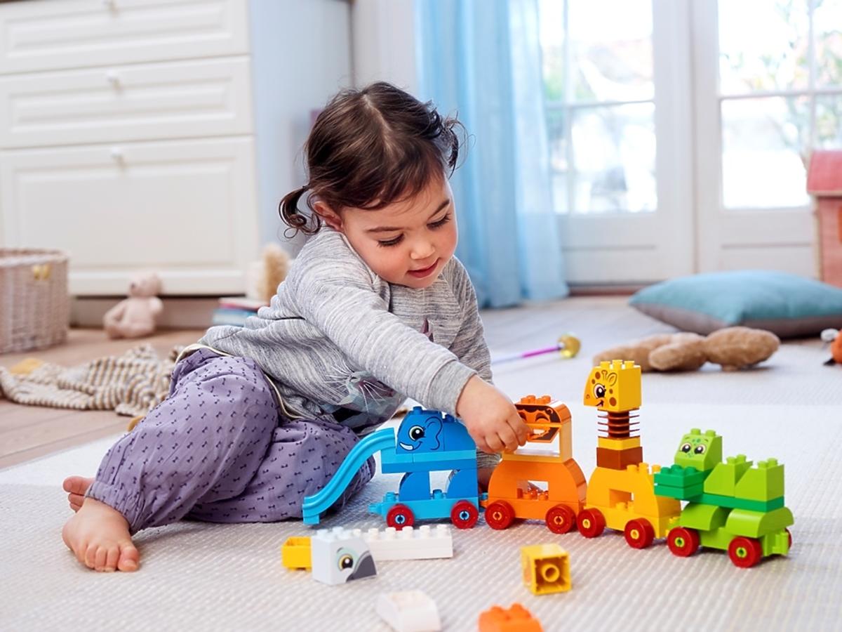 dziewczynka bawi się pociągiem ze zwierzątkami Lego Duplo