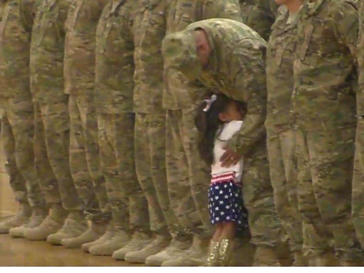 dziewczynka biegnie do taty żołnierza