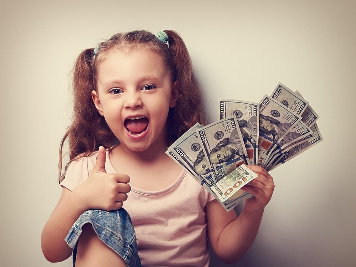 dziewczynka trzymająca w ręce dolary