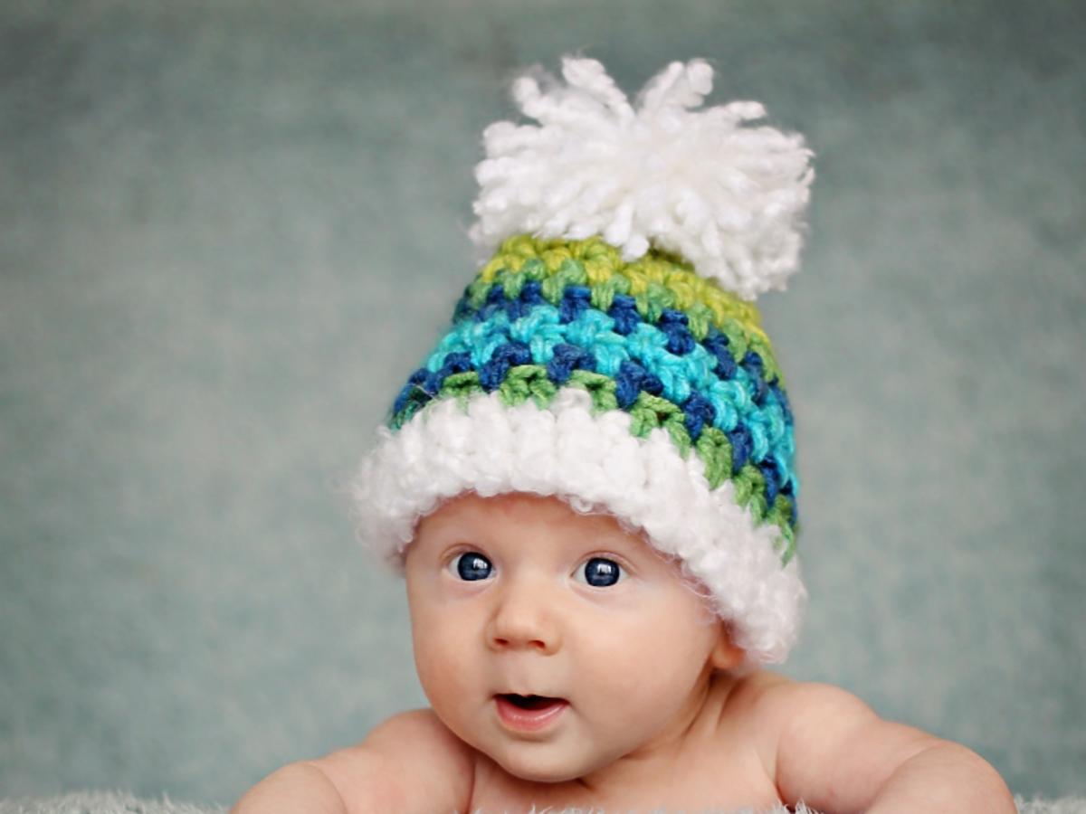 Gołe niemowlę z wielką, ciepłą czapką