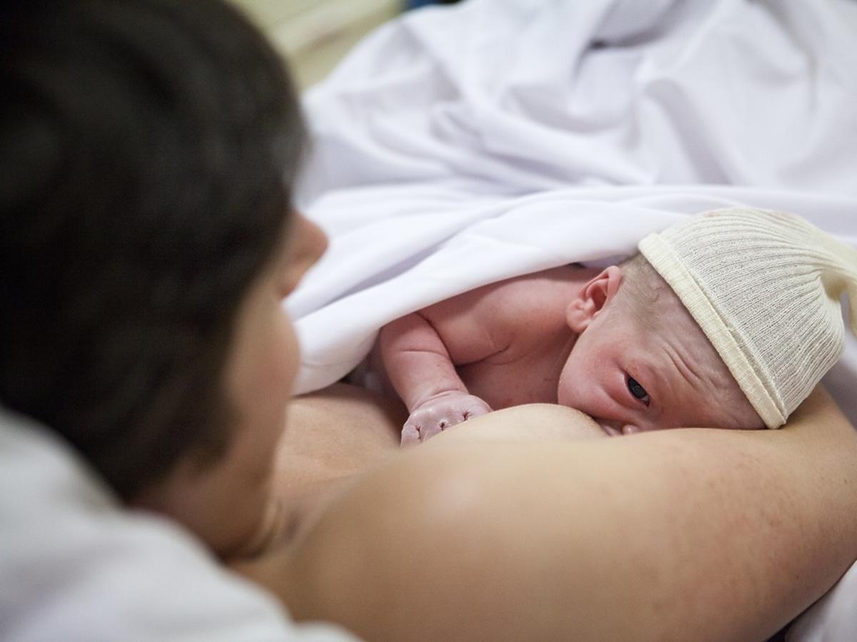 kobieta karmi piersią dziecko po urodzeniu w szpitalu
