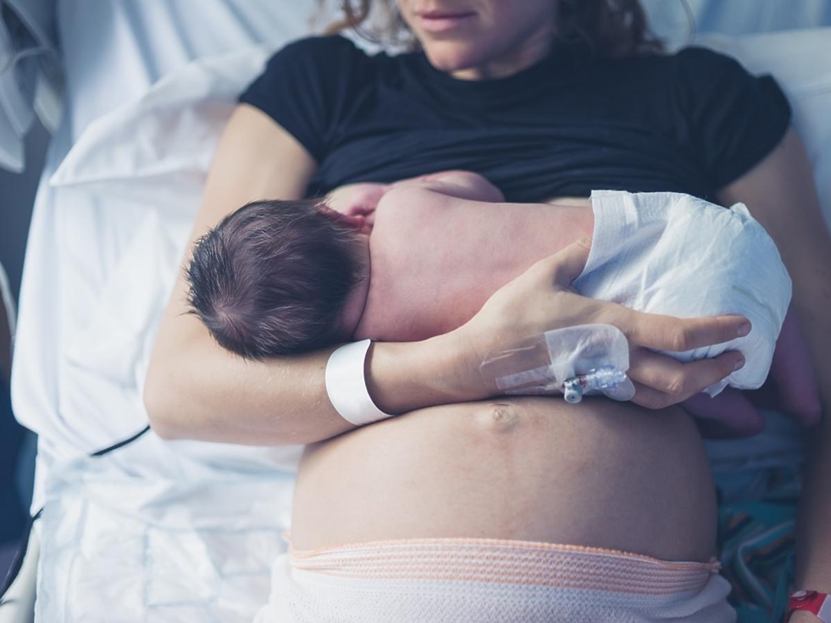 kobieta karmi piersią nowo narodzonego maluszka w szpitalu