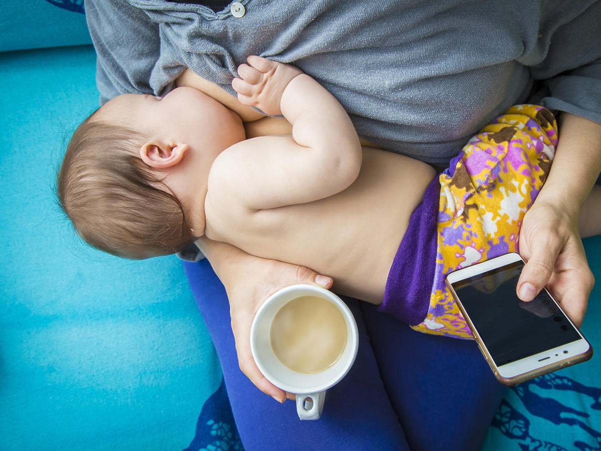 Kobieta karmiąca dziecko piersią przy kawie