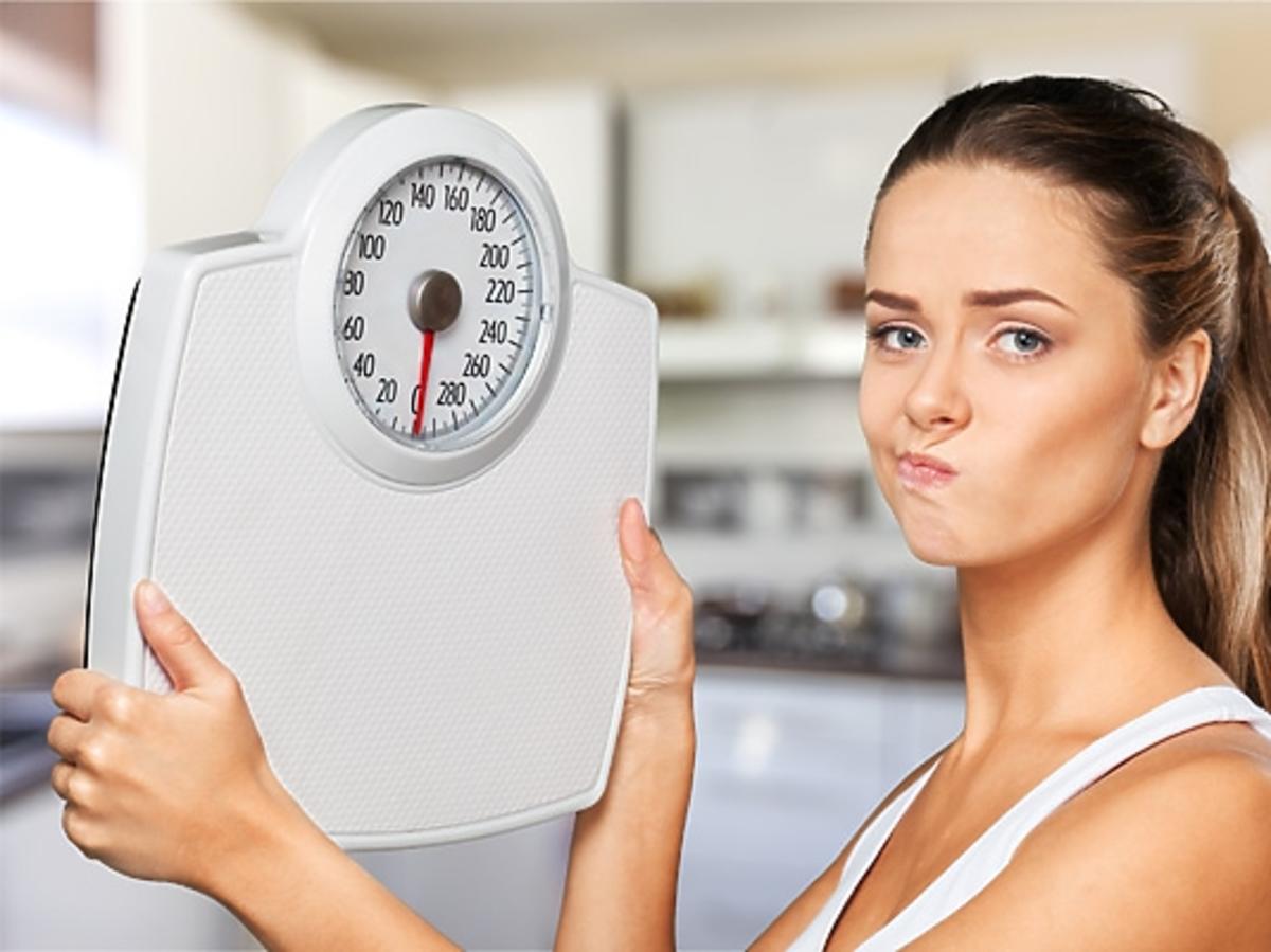 Kobieta trzyma wagę - jak schudnąć?