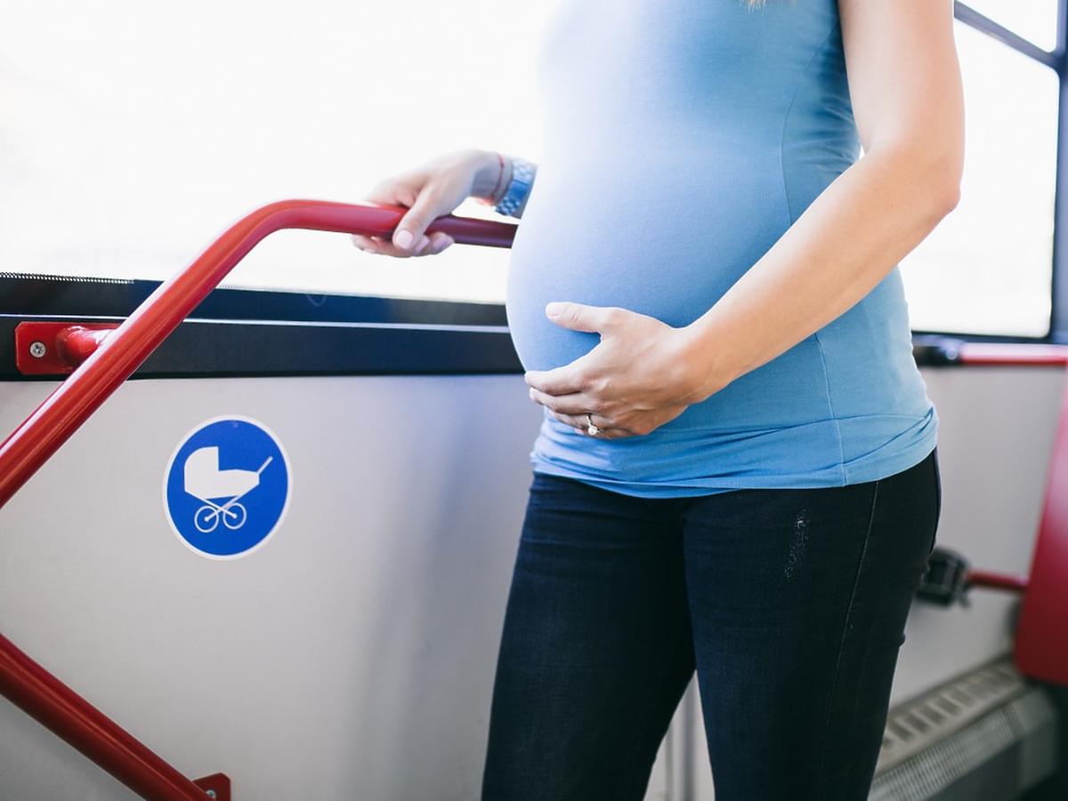 kobieta w ciąży stoi w autobusie