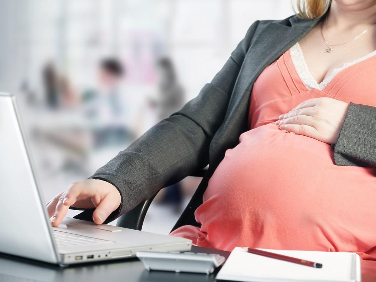 Kobieta w ciąży w pracy, przy komputerze