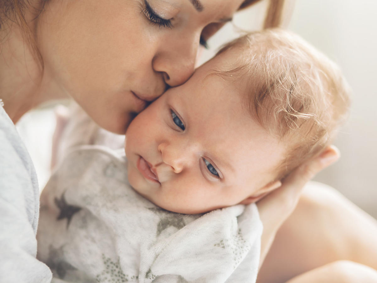 mama całująca niemowlę
