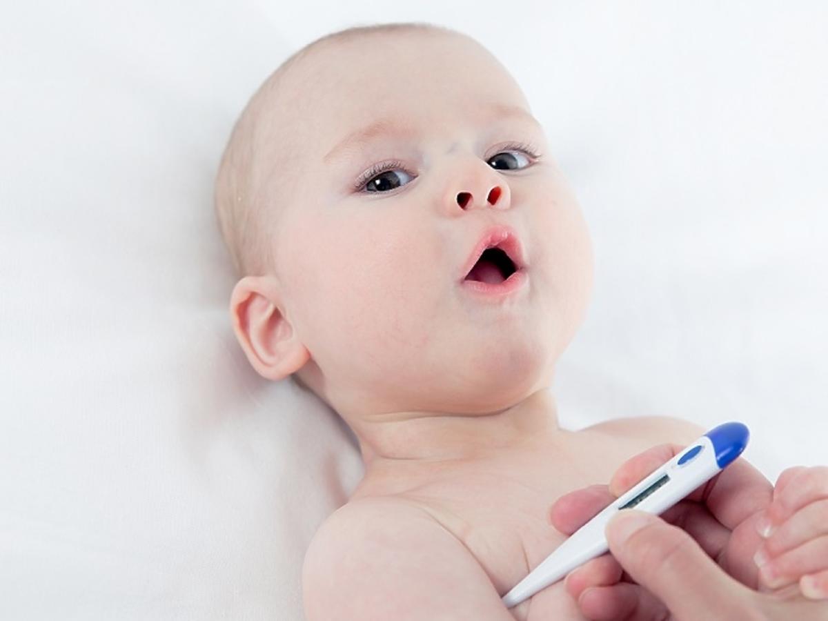 Niemowlak z termometrem - mierzenie gorączki u niemowlaka