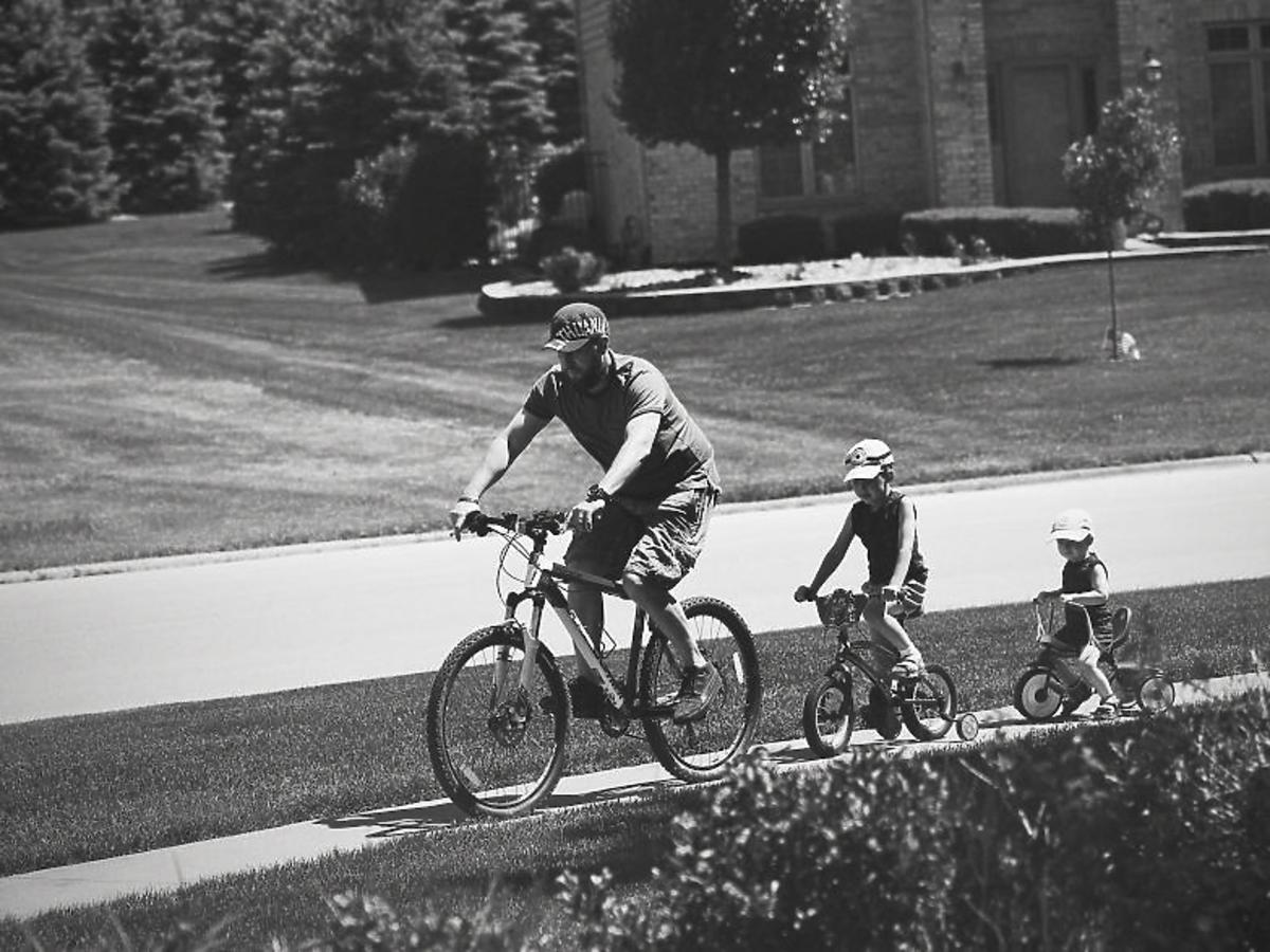 ojciec i dzieci jadą na rowerach