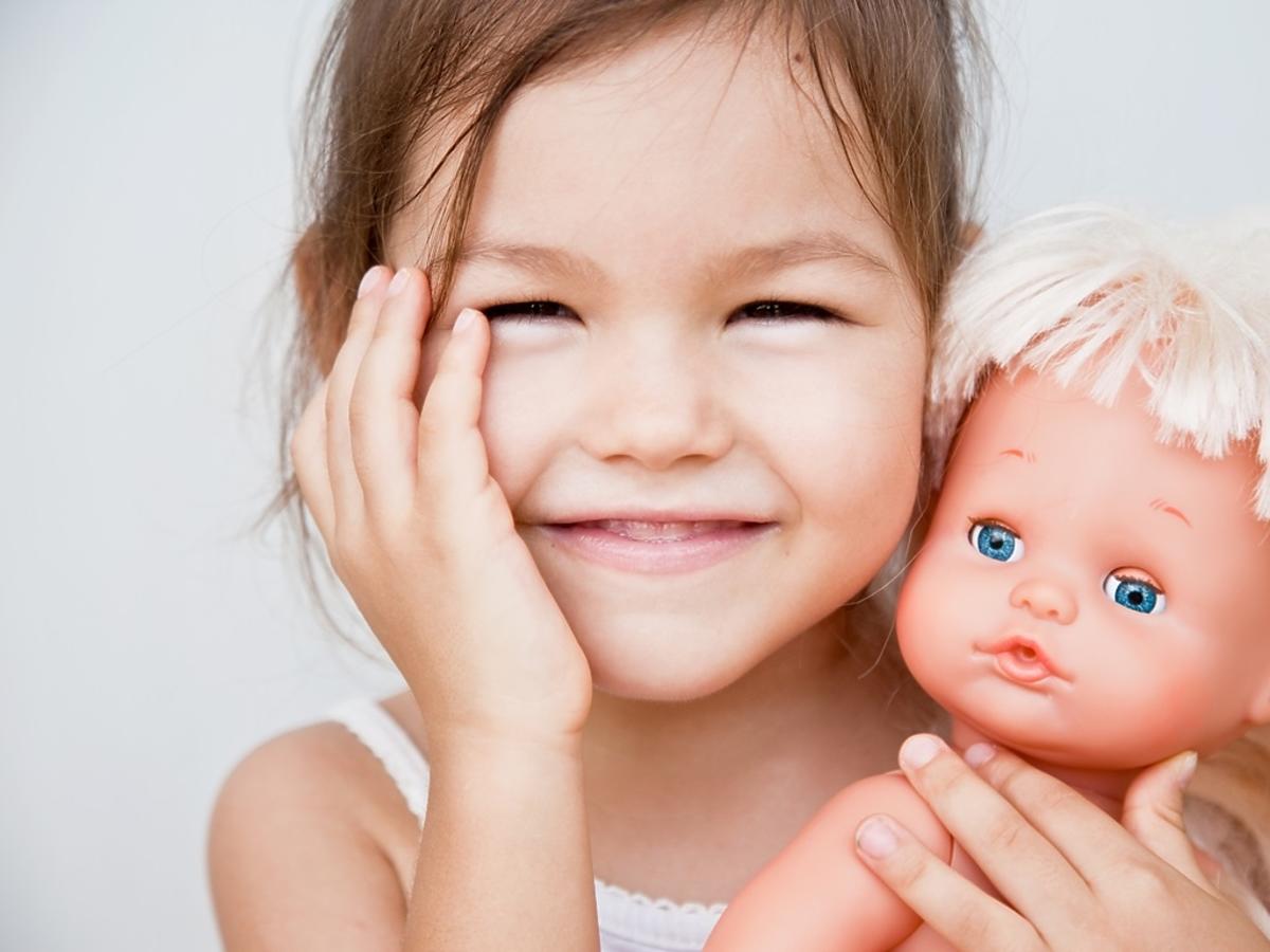 uśmiechnięta dziewczynka z lalką