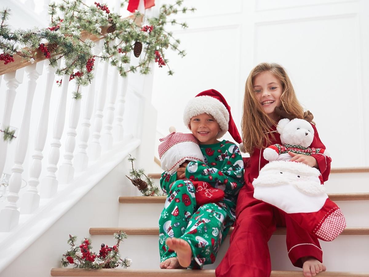 uśmiechnięte dzieci siedzą na schodach przed Świętami