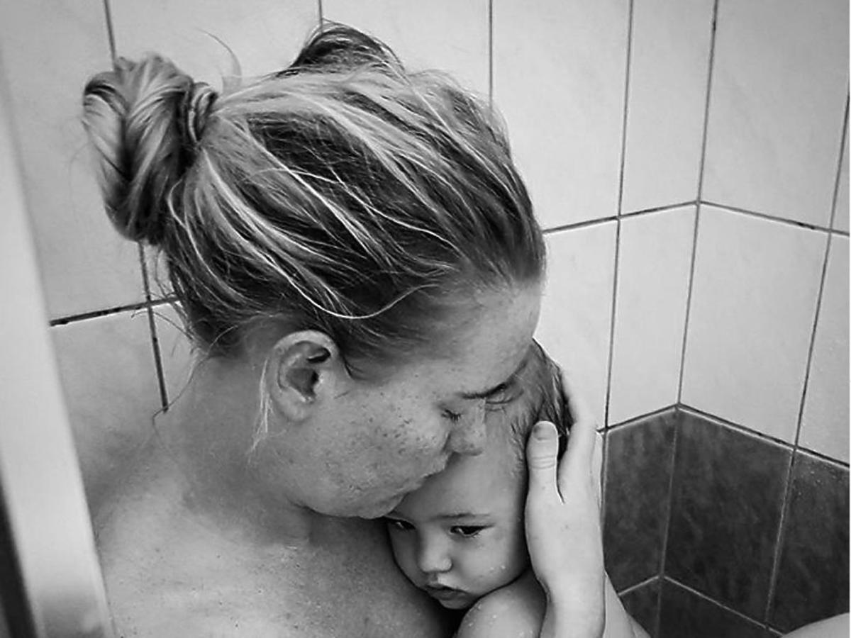 zdjęcie mamy z chorym dzieckiem pod prysznicem